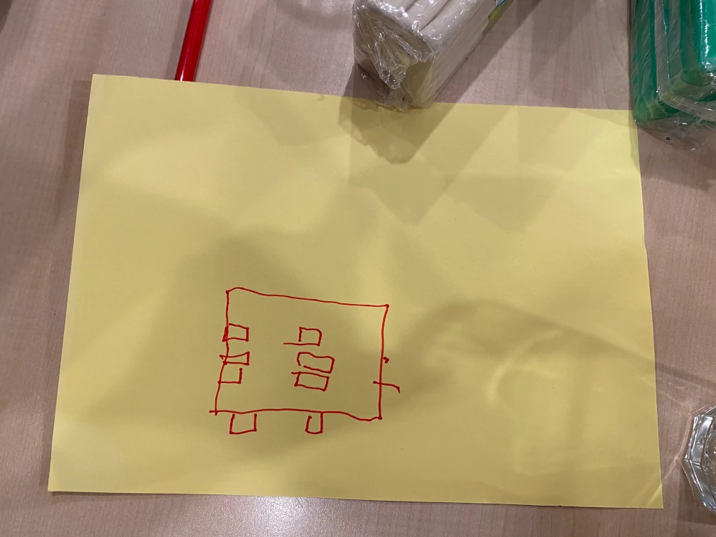 Entwurfszeichnung einer Braille-Tastatur mit einer mobilen Tastenanordnung. In rot gezeichnete Rechtecke auf einem gelben Papier.